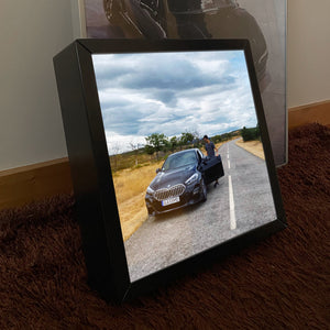 Moldura One, quadro de luz com foto de um modelo a entrar no seu BMW.